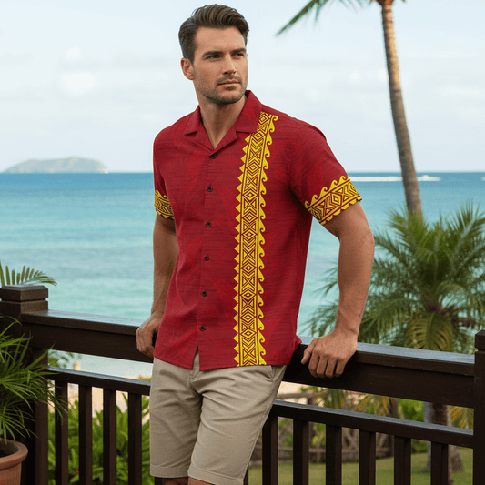 Man wearing Koa Kai Mana Hawaiian shirt with crimson red and golden yellow kapa patterns leaning against railing at outdoor bar deck overlooking ocean