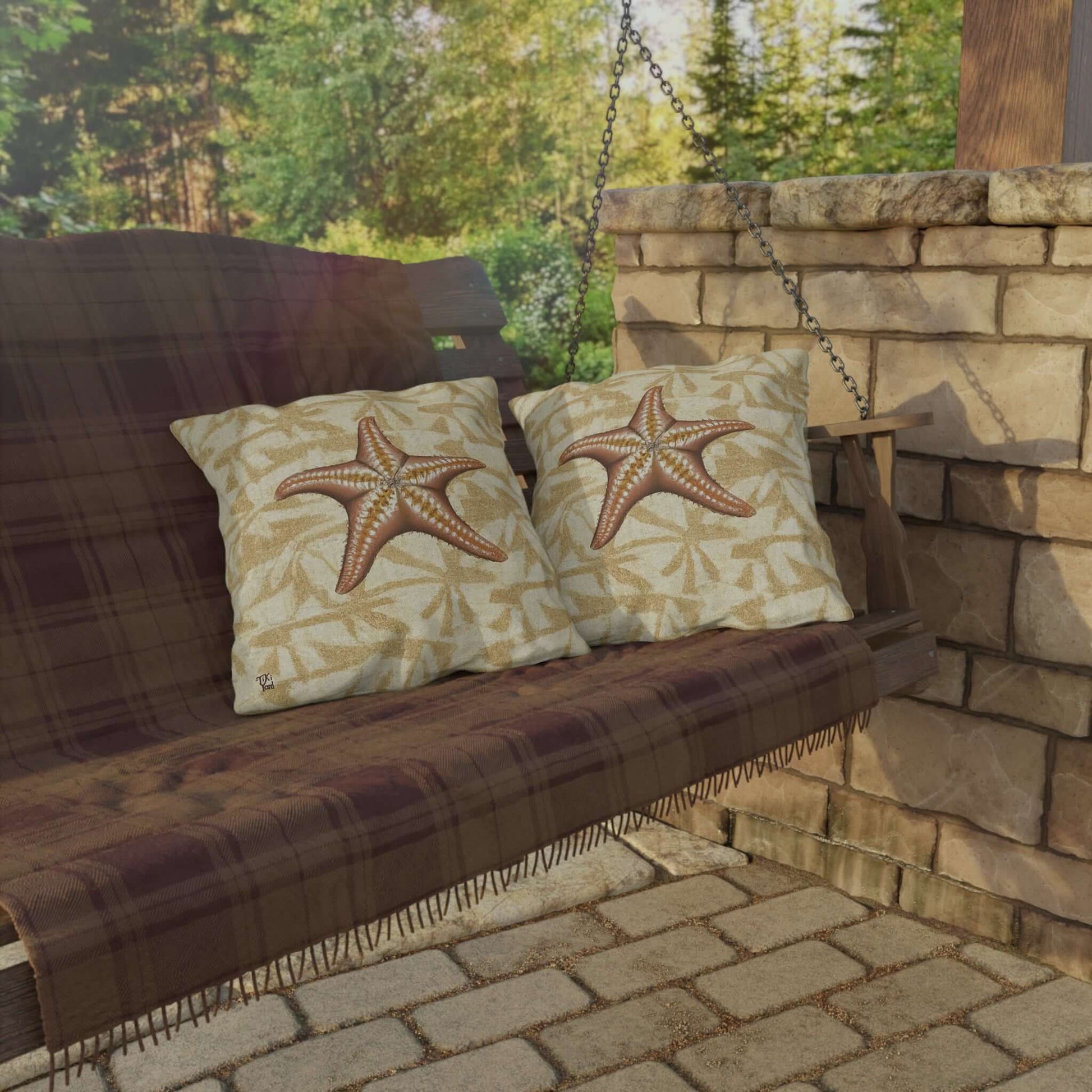 Island Star outdoor throw pillows with starfish design on a porch swing, embodying serene coastal style.