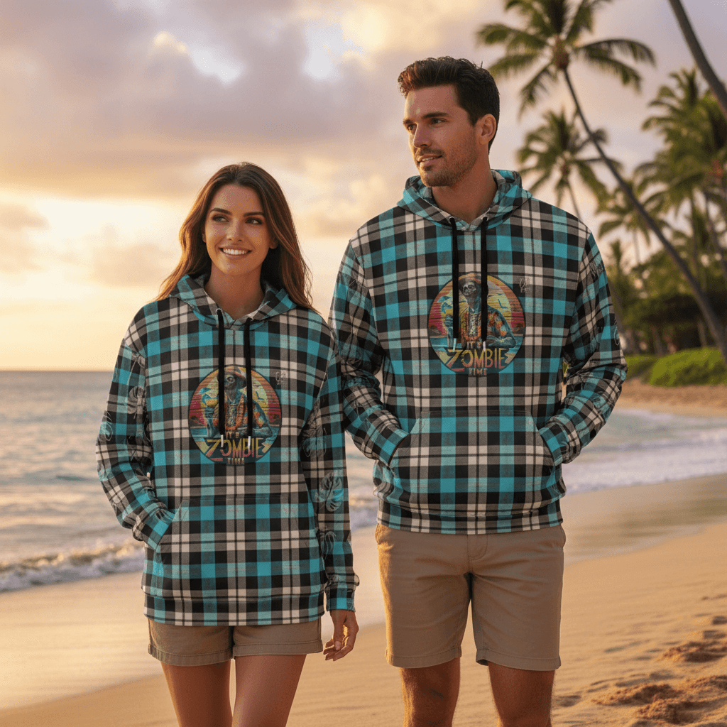 Couple wearing matching Zombie Time pullover hoodies with retro zombie tiki design walking on Hawaiian beach at sunset