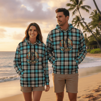 Couple wearing matching Zombie Time pullover hoodies with retro zombie tiki design walking on Hawaiian beach at sunset
