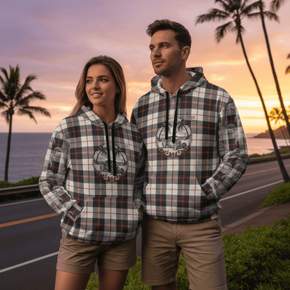 Couple wearing matching Tiki Hotrod pullover hoodies with vintage hot rod design at coastal highway overlook