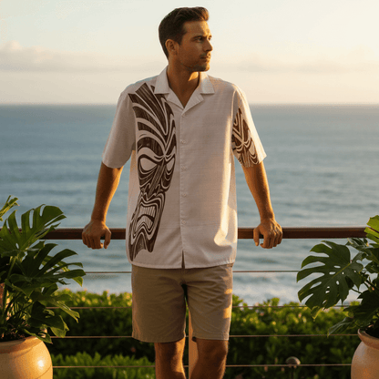 Man wearing Twisted Tiki Hawaiian shirt on oceanfront resort terrace at sunset