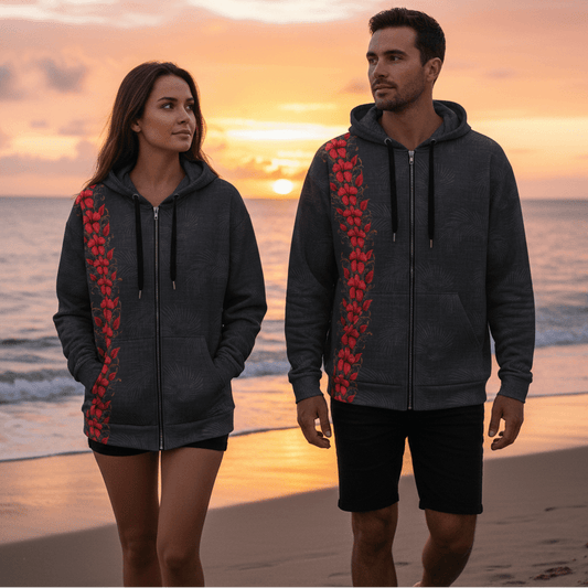 Man and woman wearing matching Midnight Aloha zip hoodies with coral plumeria flowers walking on beach at sunset